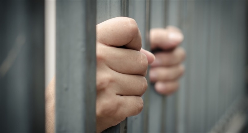 Hands-cling-to-jail-bars-Shutterstock-800x430