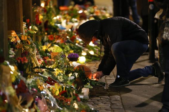 A man lights candle at memorial for victims of deadly attacks in front of synagogue in Krystalgade in Copenhagen